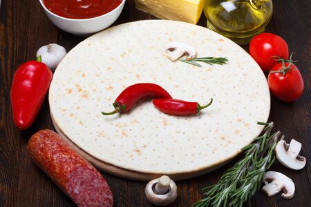 Pizza dough with different ingredients for cookingの写真素材