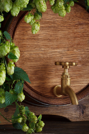 Beer barrel close-up with fresh hops on wooden table still-lifeの写真素材