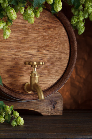 Beer barrel close-up with fresh hops on wooden table still-lifeの写真素材
