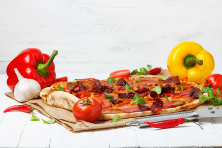 Pizza with salami and ham and cheese on wooden tableの写真素材