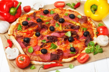 Hot pizza with ingredients on wooden table still lifeの写真素材