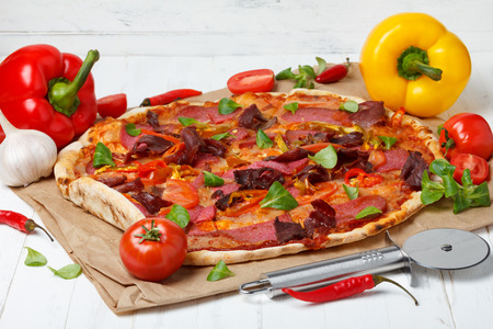 Hot pizza with ingredients on wooden tableの写真素材