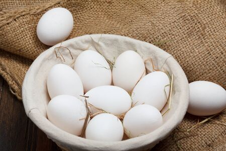 Eggs in a bowl with grass on burlap cloth still lifeの写真素材