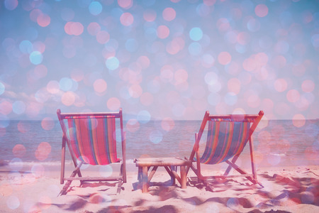 Beach chairs on sea shore with glowing party bokeh and film stylized, double exposure effectの写真素材