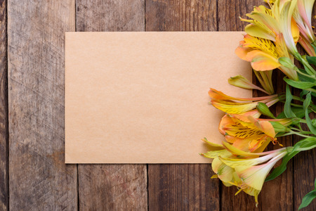 Blank paper card with lily flowers on old wooden tableの写真素材