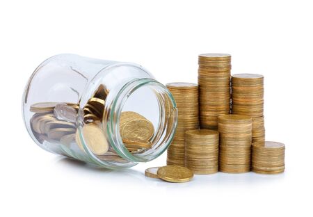 Coins stacks and glass jar full of coins isolated on white backgroundの写真素材