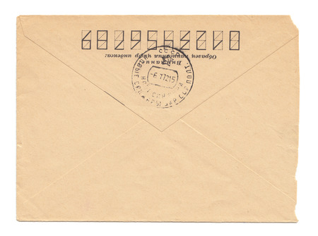 Old worn envelope with USSR meter stamp, worn and yellowed paper, closed, isolated on white background. Russian inscription: "Attention! Sample of filling zip-code"の写真素材
