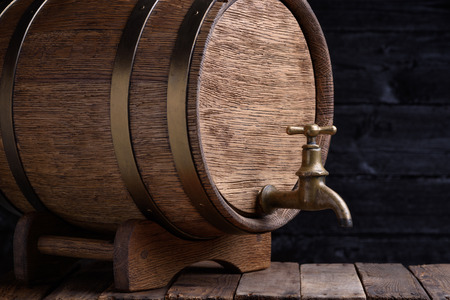 Old oak barrel on rack on grunge wooden tableの写真素材