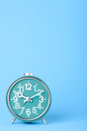 Old vintage clock on blue background with copy spaceの写真素材