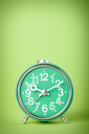 Vintage green clock on green backgroundの写真素材