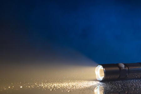 Tactical waterproof flashlight with waterdrops and fog or steamの写真素材
