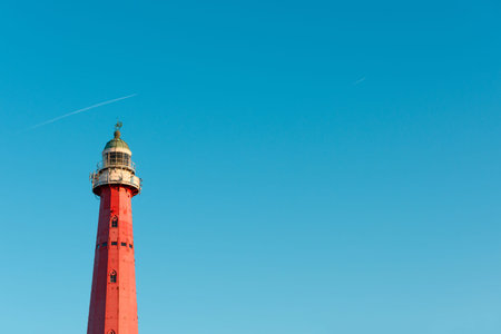 Lighthouse at sunset light over clear blue sky with copy spaceの写真素材