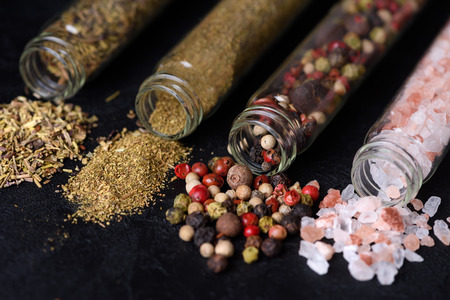 Assorted ground spices in bottles on dark slate stone backgroundの写真素材