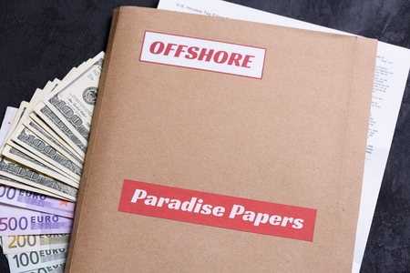 Paper folder with Paradise papers and offshore label on it with european euro and american dollar currency, offshore tax heaven documents leak conceptの写真素材