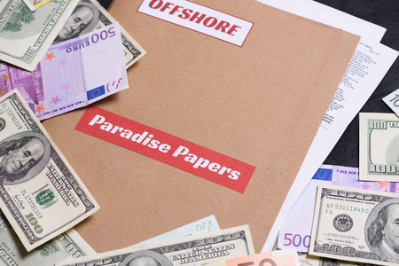 Folder with Paradise papers label on it with european and american currency, offshore tax heaven documents leak conceptの写真素材