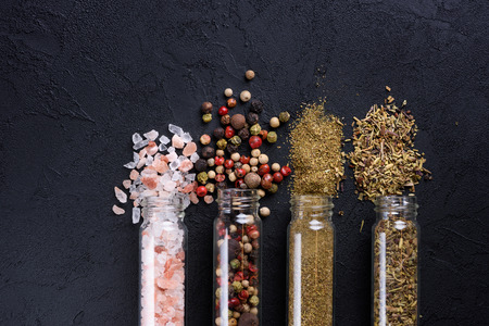 Mix of different spices in glass tubes on dark stone table flat lay top viewの写真素材
