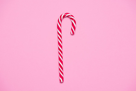 Striped red and white candy cande on pink paper backgroundの写真素材