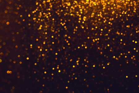 Shiny glitter bokeh. Glitter abstract background with golden lights and blank background.の写真素材