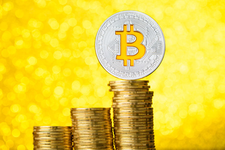 Bitcoin coin with golden bitcoin symbol on top of the coins stack stairs with gold bokeh background price rise conceptの写真素材