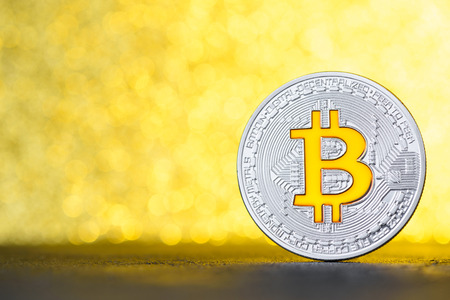 Bincoin coin on black table with gold bokeh background and copy spaceの写真素材