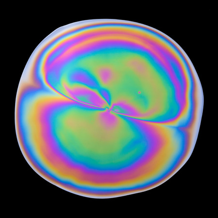 Photo of abstract colorful iridescent oil circle isolated on black backgroundの写真素材