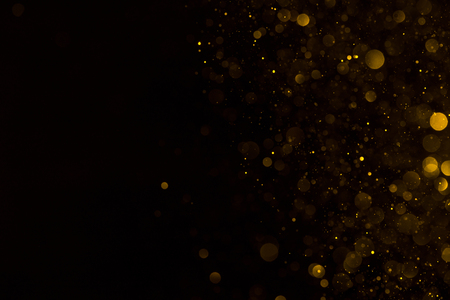 Golden glitter falling sparkle background on black border compositionの写真素材