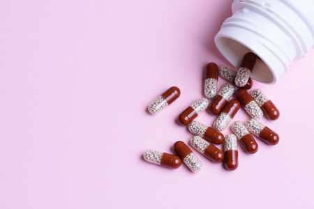 Transparent pills and pill bottle on blue backgroundの写真素材