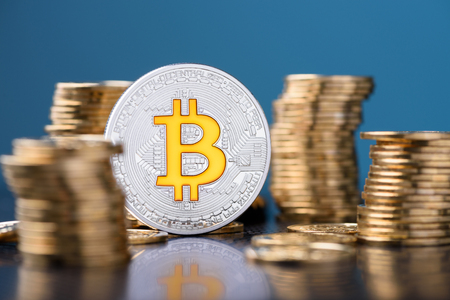 Bitcoin. Bitcoin coin between golden coins stacks with reflection.の写真素材