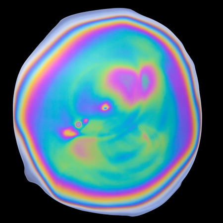 Photograph of unique abstract iridescent opalescent oil film isolated on black backgroundの写真素材