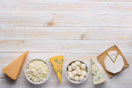 Cheese assortment on white wooden table top view flat layの写真素材