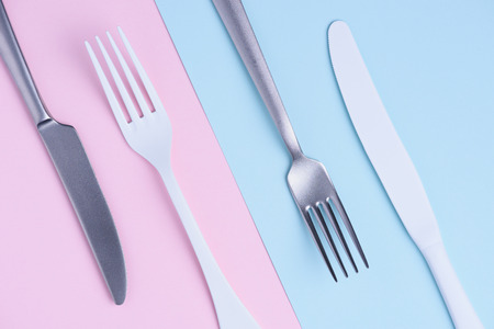 Knife and fork set on trendy soft pastel color paper backgroundの写真素材