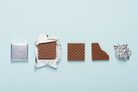 Chocolate bar cycle on blue pastel paper background conceptの写真素材