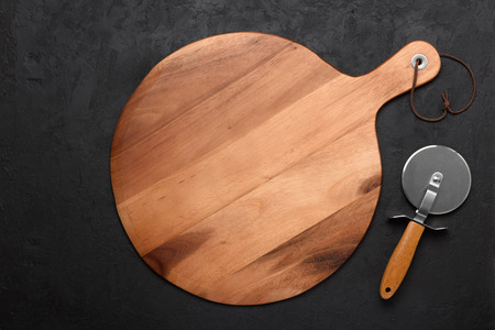 Pizza cutting board with pizza knife on dark rustic backgroundの写真素材