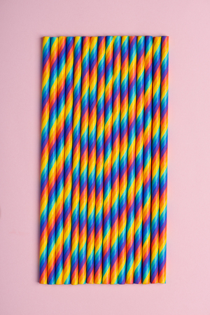 Rainbow paper cocktail straws on pink pastel backgroundの写真素材