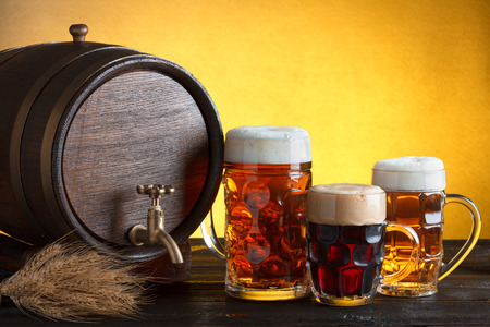 Vintage beer barrel with beer glasses on wooden table with wheat bunch, still life with copy spaceの写真素材