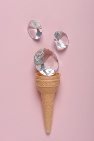 Ice cream waffer cone with shiny gems on pink pastel background flatlayの写真素材
