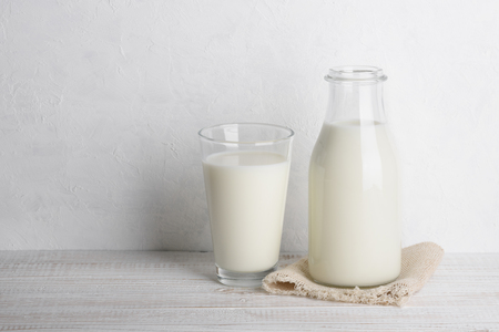 Bottle of milk and full glass on sack cloth napkinの写真素材
