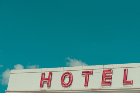 Hotel vintage neon sign text on old building with sky copy space retro color stylizedの写真素材