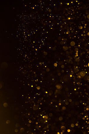 Glitter golden dust falling shiny abstract bokeh backgroundの写真素材