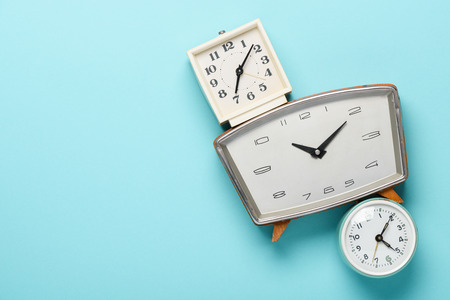 Retro alarm clocks on blue pastel background time concept flat lay top view with copy spaceの写真素材