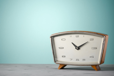 Retro classic wooden alarm clock on desk vintage color background with copy spaceの写真素材