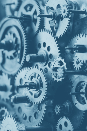 Vintage machine clock mechanism with gears and cogs macro vertical blue tonedの写真素材