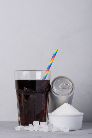 Soft drink and can with and crystal sugar on tableの写真素材