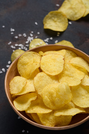 Crispy potato chips with salt in bowlの写真素材