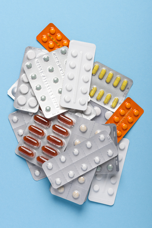 Pills blisters assortment heap on blue background top viewの写真素材