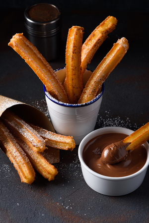 Churros with sugar and cinnamon in melted chocolate dipの写真素材