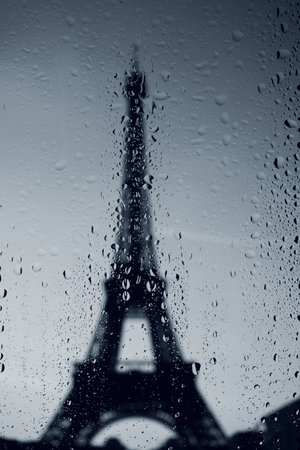 Paris Eiffel tower dark silhouette at rainy day. Water drops on the window.のeditorial素材