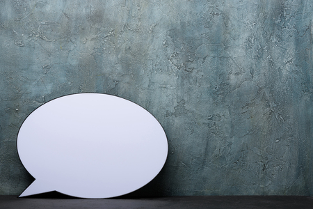 Speech Bubble lightbox on desk. Plastic light box in form of chat message icon with rustic background and copy space.の写真素材