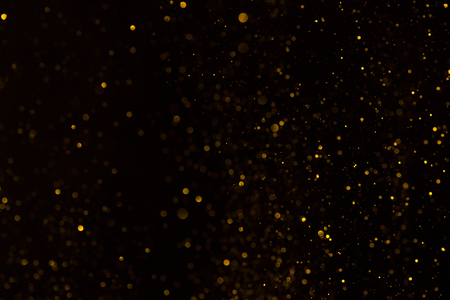 Shiny glitter fall abstract background on blackの写真素材