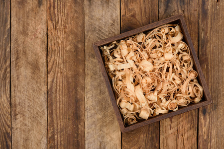 Wooden box with shavings straw filling on table. Top view.の写真素材